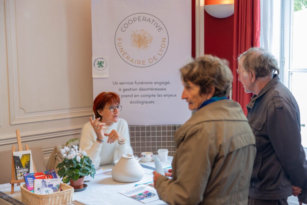 Photo d'une bénévole de la coopérative funéraire de Lyon discutant avec des visiteurs du greener festival